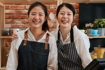 Stemp two smiling cafe workers take break for photo