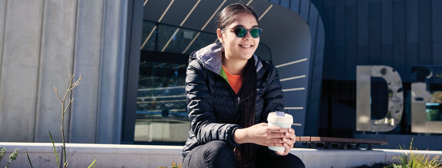 Asian female sitting with coffee cup